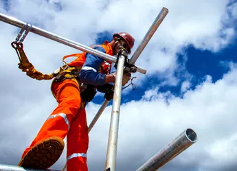 A builder on scaffolding on a sunny day
