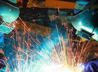 Two welders working together on a new product