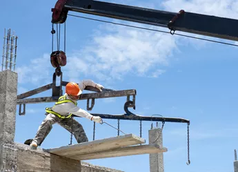 A builder pulling in a haul of wood from a crane
