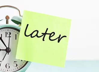 An alarm clock with 'later' written on it