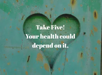 An image of a green heart on a wooden wall