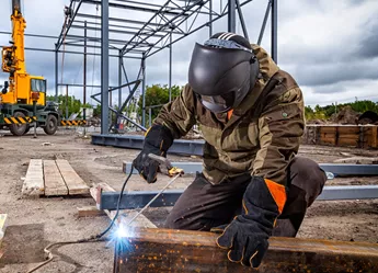 A welder on site in the early stages of a construction project