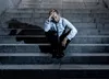 A man sitting on stone steps looking let down.