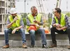 Three builders taking a tea break on a UK construction site